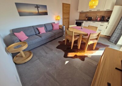 Couch, Esstisch und Küche im roten Apartment