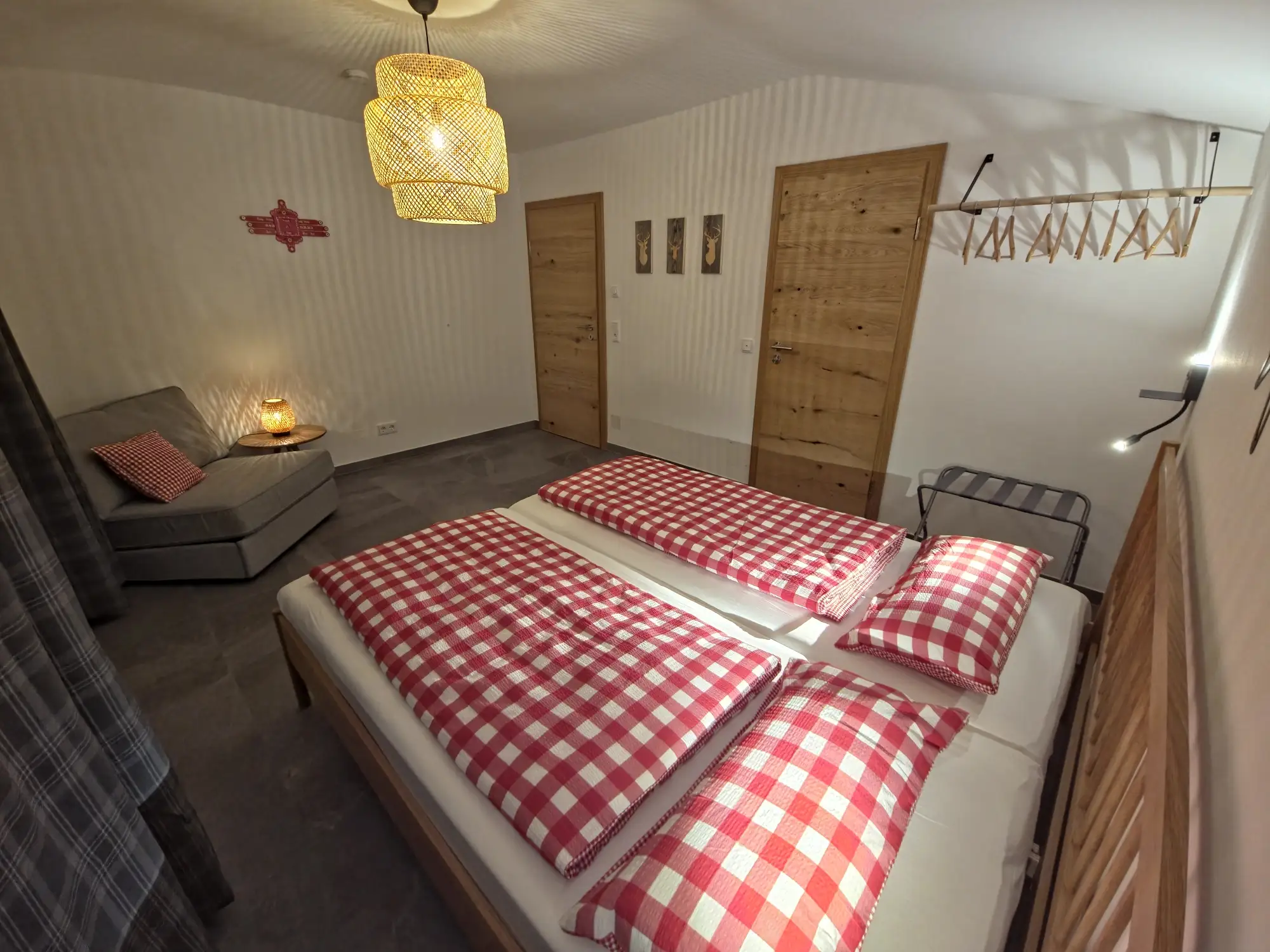 Schlafzimmer im Roten Apartment Kingsize-Bett und Kofferablage und Tür zum Badezimmer